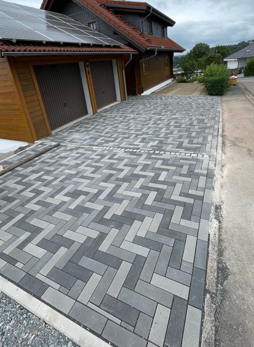eine-schoene-gepflasterte-hofeinfahrt-im-fischgraetenmuster